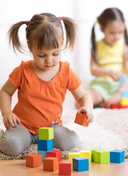Ein Mädchen spielt mit Bauklötzchen